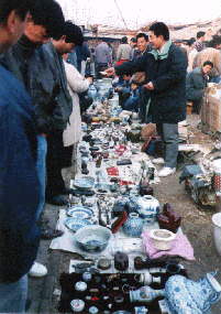 Ghost Market sellers hunkered over their blankets