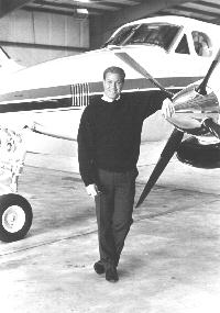 Tom Sylvester standing by his plane